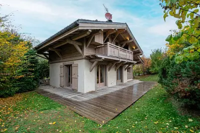 a house with a wooden deck in a yard at Superb Chalet Isatis-renovated in Megeve in Megève