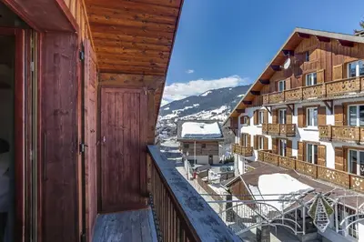 an open door to a balcony with snow covered buildings at Cozy 2BDR-5P apartment near the ski slopes in Megève