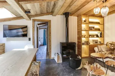 a living room with a fireplace and a living room with wooden ceilings at Cozy 2BDR-5P apartment near the ski slopes in Megève