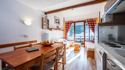 a kitchen and dining room with a wooden table at Grand Morillon N404 2P6 Mezzanine in Morillon