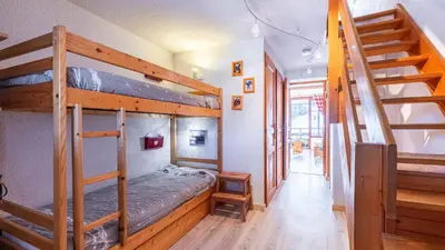 a bedroom with two bunk beds and a staircase at Grand Morillon N404 2P6 Mezzanine in Morillon