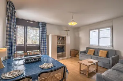 a living room with a table and a couch at Appartement L'Écrin du Mont d'Arbois - Welkeys in Saint-Gervais-les-Bains