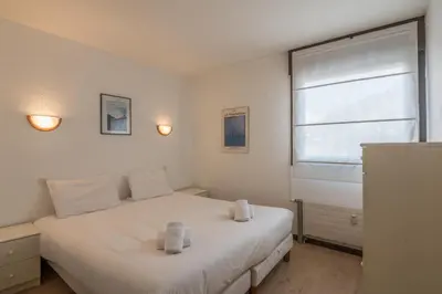 a bedroom with a white bed and a window at Appartement L'Écrin du Mont d'Arbois - Welkeys in Saint-Gervais-les-Bains