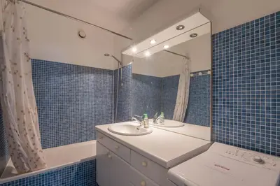 a blue tiled bathroom with a sink and a tub at Appartement L'Écrin du Mont d'Arbois - Welkeys in Saint-Gervais-les-Bains