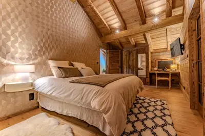 a bedroom with a large bed and a desk at Luxurious Chalet with Sauna & Jacuzzi in Megeve with Parking in Megève