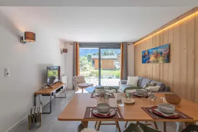 a living room with a table and a couch at Beautiful apartment in 5 stars residence with pool in Chamonix-Mont-Blanc