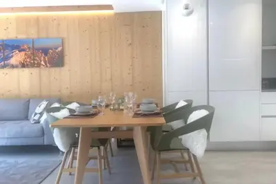a dining room with a wooden table and chairs at Beautiful apartment in 5 stars residence with pool in Chamonix-Mont-Blanc