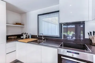 a white kitchen with a sink and a window at Beautiful apartment in 5 stars residence with pool in Chamonix-Mont-Blanc