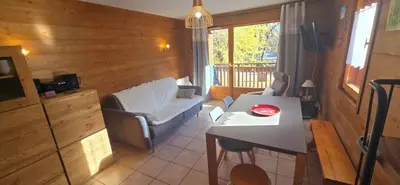 a living room with a couch and a table at LES BEULETTES b in Samoëns