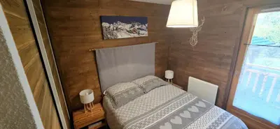 a small bedroom with a bed and a window at LES BEULETTES b in Samoëns