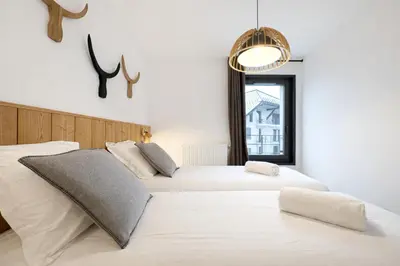 two beds in a white room with a window at Les Sources de Canopee - Calme, Vue & Ski in Saint-Gervais-les-Bains