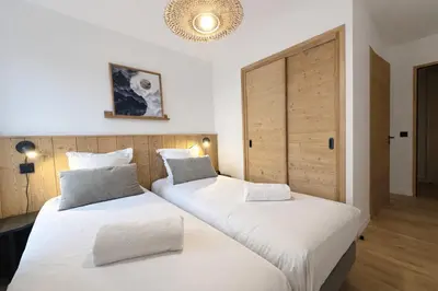 two beds in a hotel room with white sheets at Les Sources de Canopee - Calme, Vue & Ski in Saint-Gervais-les-Bains
