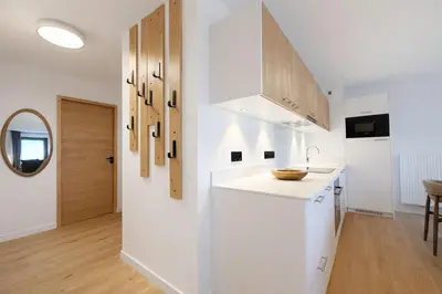 a white kitchen with a counter and a sink at Les Sources de Canopee - Calme, Vue & Ski in Saint-Gervais-les-Bains