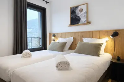 two beds in a room with a window at Les Sources de Canopee - Calme, Vue & Ski in Saint-Gervais-les-Bains