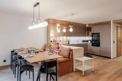 a dining room and kitchen with a table and a couch at LAiguille Verte -Sejour familial - Grands Montets in Chamonix-Mont-Blanc