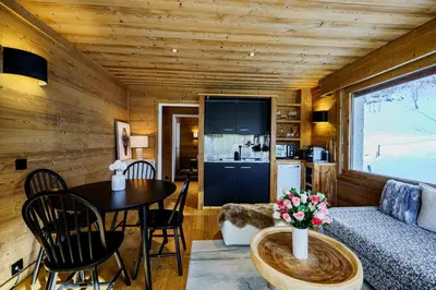 a living room with a couch and a table at Appartement Le Pacha - Proche Centre Ville in Megève