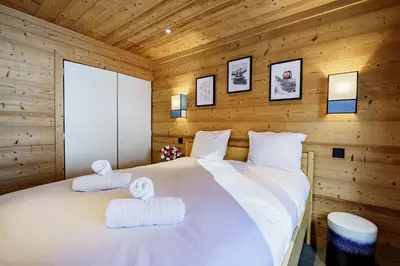 a bedroom with a white bed with towels on it at Appartement Le Pacha - Proche Centre Ville in Megève