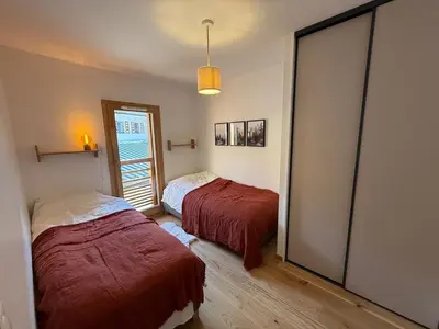 a bedroom with two beds and a window at Contamines Montjoie appartement 2 chambres et cabine in Les Contamines-Montjoie