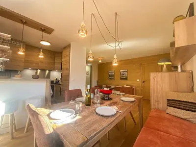 a dining room and kitchen with a wooden table at Contamines Montjoie appartement 2 chambres et cabine in Les Contamines-Montjoie