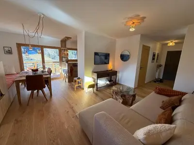 a living room with a couch and a table at Contamines Montjoie appartement 2 chambres et cabine in Les Contamines-Montjoie