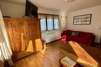 a living room with a red couch and a table at Stay at the heart of the slopes in Megève! in Megève