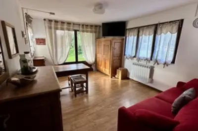 a living room with a red couch and a table at Stay at the heart of the slopes in Megève! in Megève