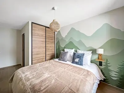 a bedroom with a bed with a mountain mural on the wall at DBA003 - 4 pieces 6 pers neuf centre in Les Carroz d'Araches