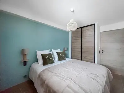 a bedroom with a large white bed with a blue wall at DBA003 - 4 pieces 6 pers neuf centre in Les Carroz d'Araches