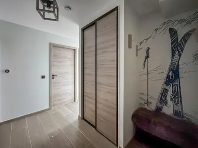 a room with a sliding door with a painting on the wall at DBA003 - 4 pieces 6 pers neuf centre in Les Carroz d'Araches