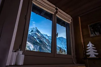 a window with a view of a snowy mountain at Balcons de Champraz- Spectacular Mont Blanc and Lake Views in Chamonix-Mont-Blanc