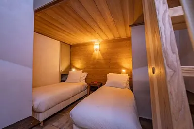 two beds in a small room with a wooden ceiling at Balcons de Champraz- Spectacular Mont Blanc and Lake Views in Chamonix-Mont-Blanc