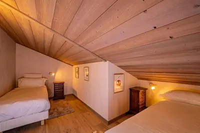 a bedroom with two beds and a wooden ceiling at Balcons de Champraz- Spectacular Mont Blanc and Lake Views in Chamonix-Mont-Blanc