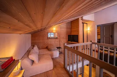 a living room with a couch and a staircase at Balcons de Champraz- Spectacular Mont Blanc and Lake Views in Chamonix-Mont-Blanc