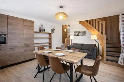 a kitchen and dining room with a table and chairs at Duplex Saint Gervais - Ski, piscine & vue in Saint-Gervais-les-Bains