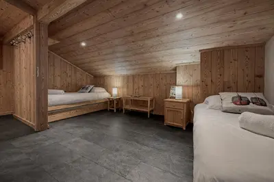 a bedroom with two beds in a wooden cabin at Duplex Saint Gervais - Ski, piscine & vue in Saint-Gervais-les-Bains