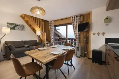 a living room with a table and a couch at Duplex Saint Gervais - Ski, piscine & vue in Saint-Gervais-les-Bains