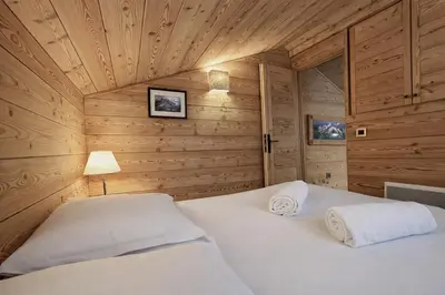 a bedroom with a bed in a wooden cabin at Duplex Saint Gervais - Ski, piscine & vue in Saint-Gervais-les-Bains
