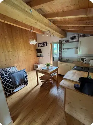 a living room with a table and a kitchen at petit chalet in Chamonix-Mont-Blanc