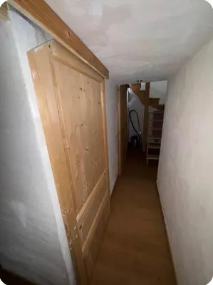 a hallway with a wooden door in a room at petit chalet in Chamonix-Mont-Blanc
