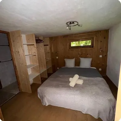 a bedroom with a bed with a cross on it at petit chalet in Chamonix-Mont-Blanc