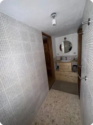 a bathroom with a shower with a tiled wall at petit chalet in Chamonix-Mont-Blanc