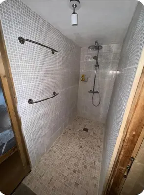 a bathroom with a shower with white tiles at petit chalet in Chamonix-Mont-Blanc