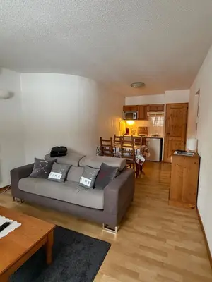 a living room with a couch and a table at Sympathique appartement à Samoëns in Samoëns