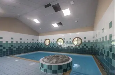 a large swimming pool with a tub in a room at Sympathique appartement à Samoëns in Samoëns