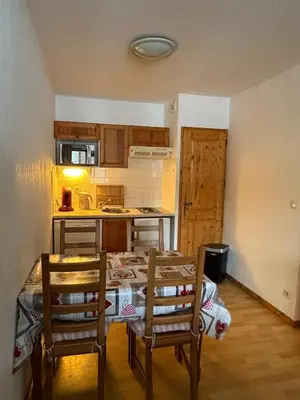 a kitchen with a table and chairs in a room at Sympathique appartement à Samoëns in Samoëns