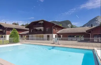 a large swimming pool in front of a house at Sympathique appartement à Samoëns in Samoëns