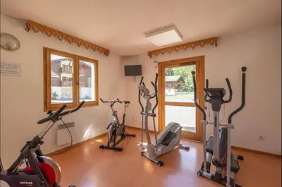 a gym with several exercise bikes in a room at Sympathique appartement à Samoëns in Samoëns