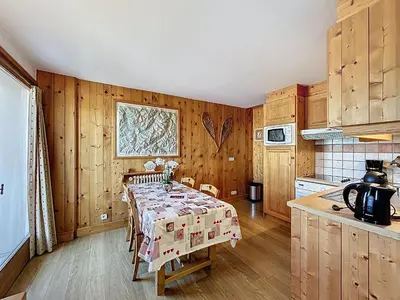 a kitchen with a table in the middle of a room at Appartement 3 Pièces avec Parking et Vue Mont Blanc - FR-1-560-174 in Combloux
