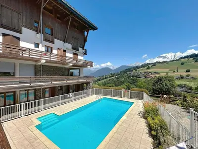 a swimming pool in front of a building at Appartement 3 Pièces avec Parking et Vue Mont Blanc - FR-1-560-174 in Combloux