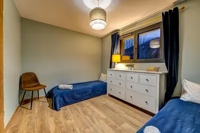 a bedroom with two beds and a dresser and a window at Beautiful new flat by the forest in Chamonix-Mont-Blanc